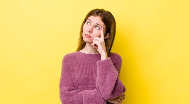 Avec un regard concentré se demandant avec une expression douteuse regardant vers le haut et sur le côté