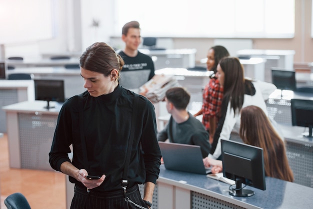 Regard réfléchi. Groupe de jeunes en vêtements décontractés travaillant dans le bureau moderne