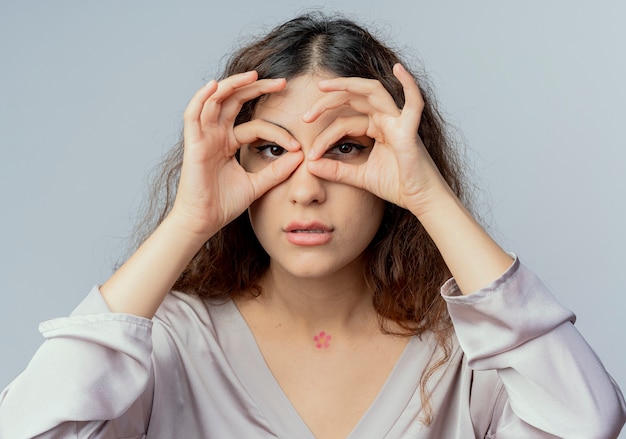 Photo gratuite regardant la caméra jeune employé de bureau jolie femme montrant le geste de regard isolé sur fond blanc