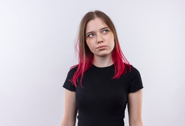 Regardant le côté jeune belle fille portant un t-shirt noir sur fond blanc isolé avec copie côté