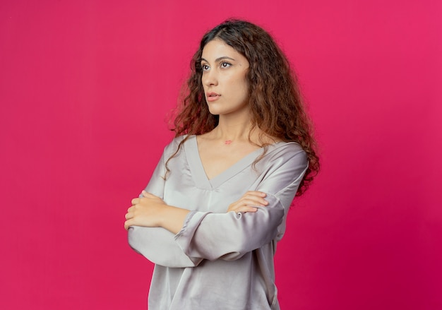 Regardant le côté jeune jolie fille croisant les mains