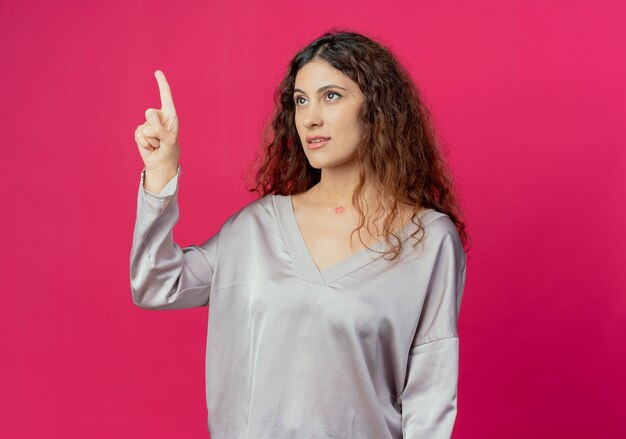 Photo gratuite regardant le côté jeune jolie fille pointe vers le haut