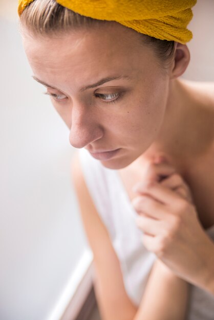 En regardant par la fenêtre. Des jeunes femmes réfléchies regardent par la fenêtre. Attractive fille triste debout à la fenêtre en regardant