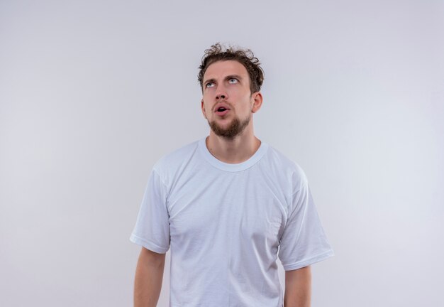 Regardant la pensée de jeune homme portant un t-shirt blanc sur fond blanc isolé