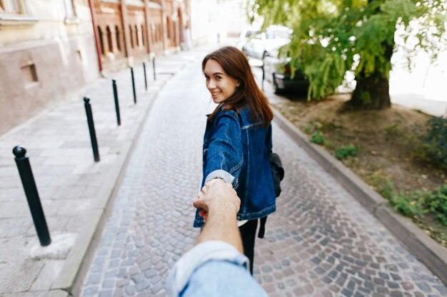 Regarder par derrière à la jeune femme tenant la main de l&#39;homme dans la pose «Suivez-moi»