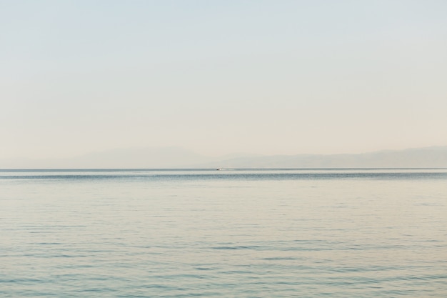 Regardez depuis le rivage à la mer sans fin et au bateau