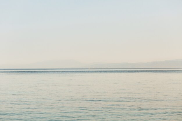 Regardez depuis le rivage à la mer sans fin et au bateau