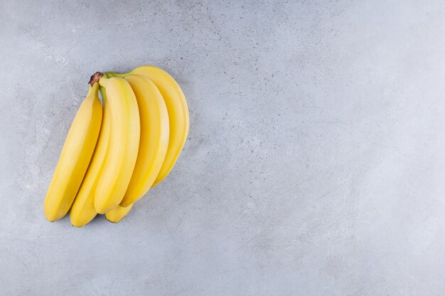 Régime de banane posé sur une table en pierre.