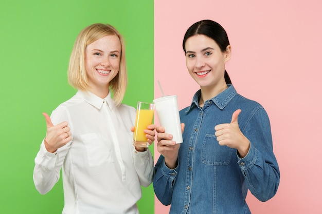 Régime. Concept De Régime. La Nourriture Saine. Belles Jeunes Femmes Choisissant Entre Le Jus D'orange Aux Fruits Et Une Boisson Sucrée Gazeuse Sans Hâte