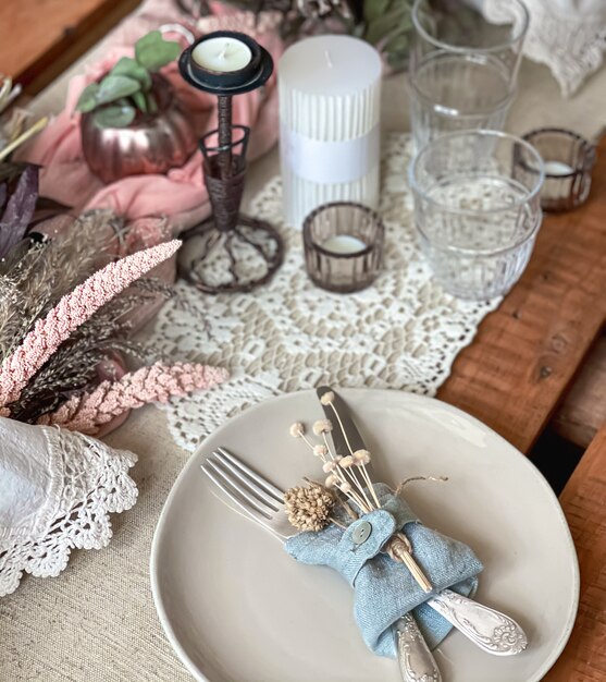 Réglage de la table de fête avec des brins de fleurs séchées et des éléments décoratifs.