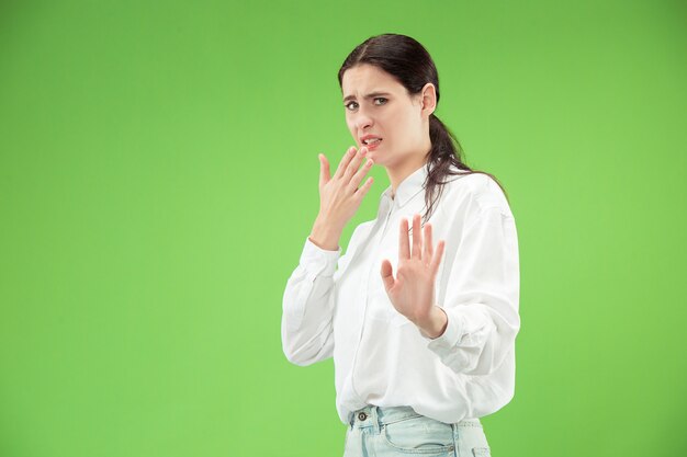 Rejeter, rejeter, douter du concept. Femme douteuse avec une expression réfléchie faisant un choix. Jeune femme émotionnelle. Émotions humaines, concept d'expression faciale. Studio. Isolé sur vert branché