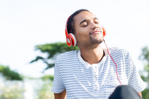 Photo gratuite relaxé jeune homme aimant la musique appréciant la nature