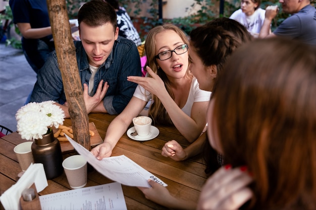 Remue-méninges informel d'une jeune équipe au restaurant confortable et commande de nourriture