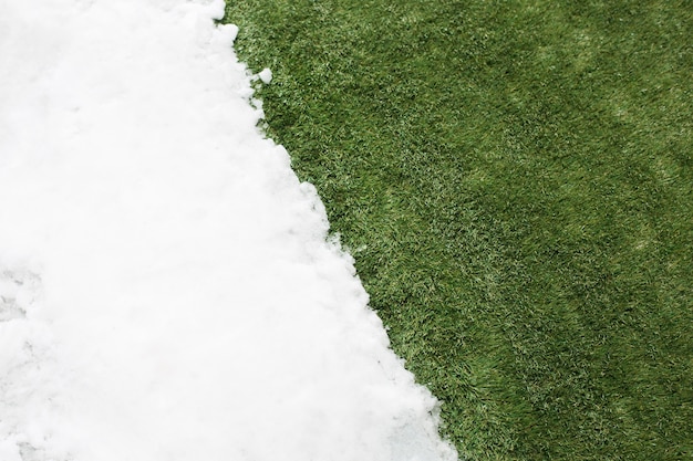 Photo gratuite rencontre neige blanche et herbe verte se bouchent. entre fond de concept hiver et printemps.