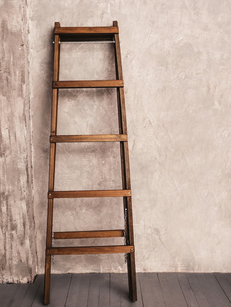 Photo gratuit rénovation d'appartement. échelle en bois dans une pièce vide
