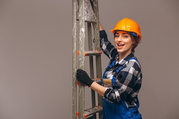 Réparateur de femme avec échelle en uniforme isolé