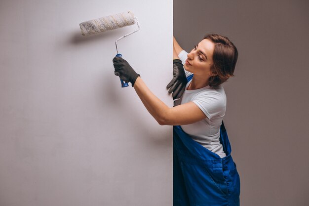 Réparateur de femme avec rouleau de peinture isolé