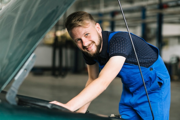 Photo gratuite réparateurs fixant la voiture au garage