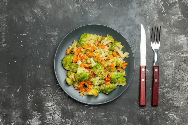 Repas sain avec brocoli et carottes sur une plaque noire sur table grise