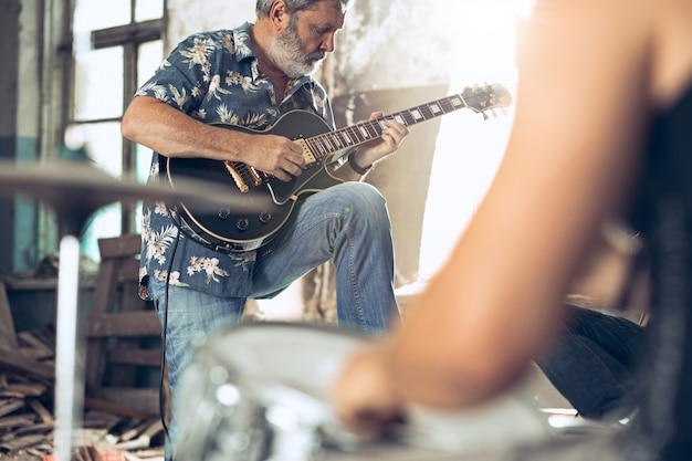 Répétition du groupe de musique rock. Joueur de guitare électrique et batteur derrière la batterie.