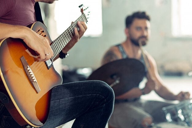 Répétition du groupe de musique rock. Joueur de guitare électrique et batteur derrière la batterie.