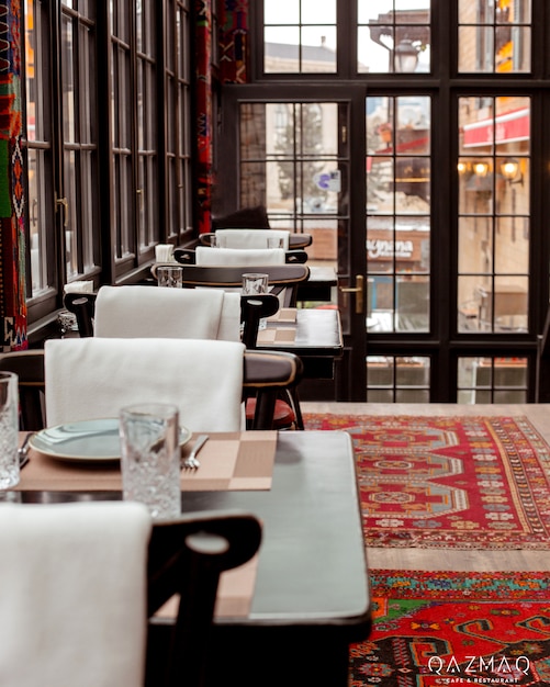 Photo gratuite restaurant avec tapis rouge au sol tables et chaises