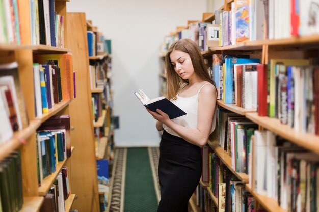 Retour au concept d&#39;école avec une femme étudiant en bibliothèque