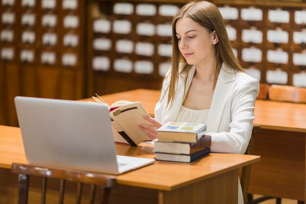 Retour au concept d&#39;école avec une femme étudiant en bibliothèque