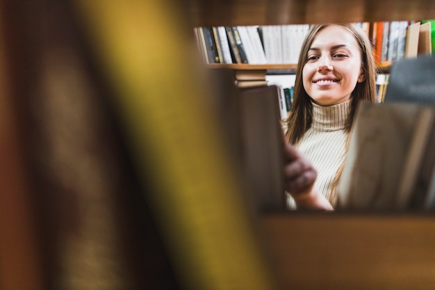 Photo gratuite retour au concept d'école avec une femme étudiant en bibliothèque