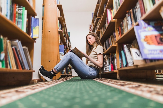 Retour au concept d&#39;école avec une femme étudiant en bibliothèque