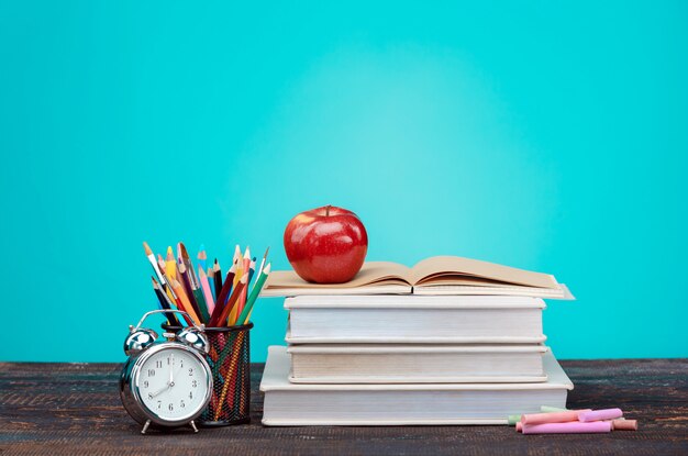 Retour au concept de l'école. Livres, crayons de couleur et horloge