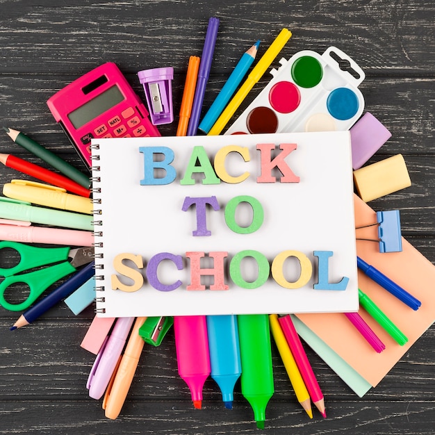 Photo gratuite retour au fond de l'école avec des fournitures scolaires et un cahier