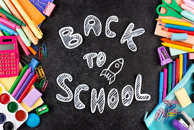 Retour au fond de l'école avec des fournitures scolaires sur tableau noir