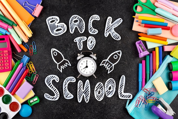 Photo gratuite retour au fond de l'école avec des fournitures scolaires sur tableau noir