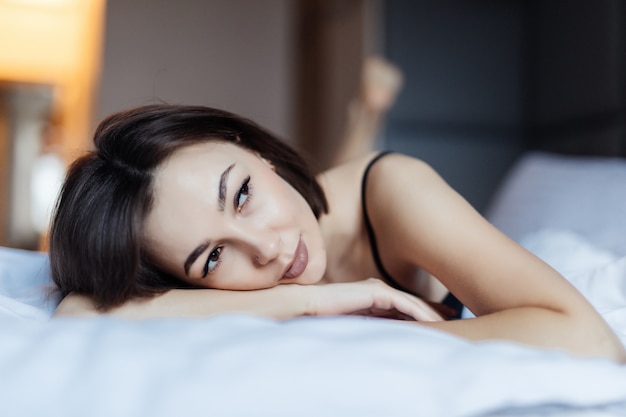 Rêve de jeune femme sexy au lit tôt le matin