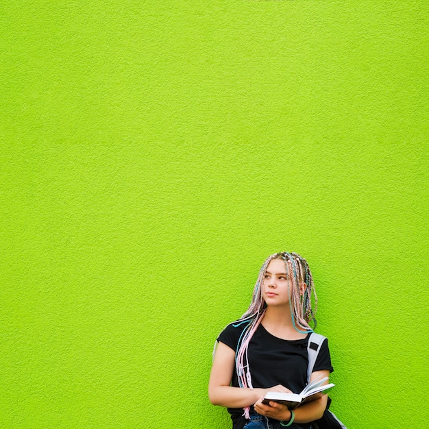 Rêverie fille posant avec un livre