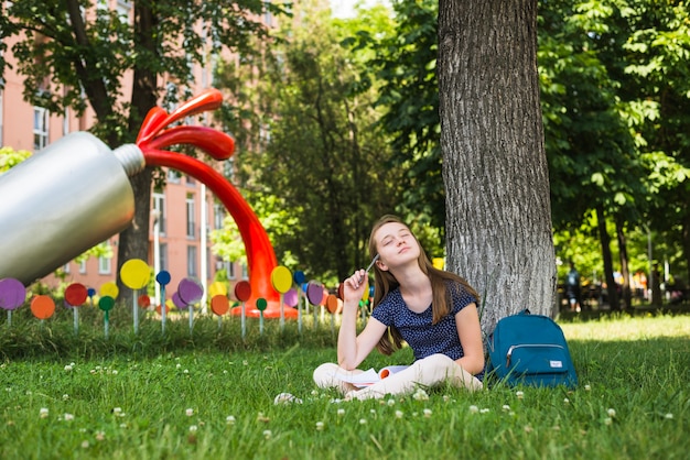 Photo gratuite rêveur avec des études sur la pelouse