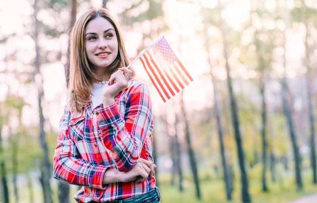 Rêveuse jeune femme avec petit drapeau américain