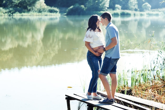 Rire en attendant couple se dresse sur le pont au-dessus de la rivière