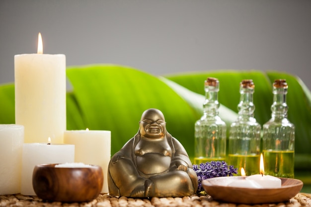 Rire Buddha Figurine, Bougie Allumée, Des Bouteilles D'huile De Massage Et De Sel De Mer Photo gratuit