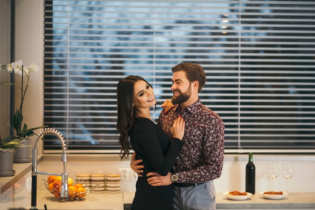 Rire couple posant dans la cuisine