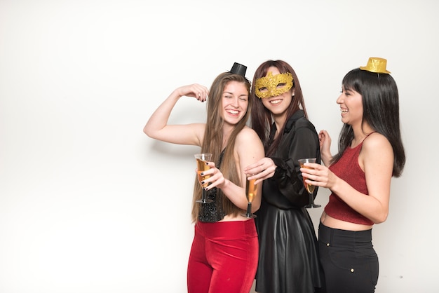 Rire dames en tenue de soirée avec des verres de boissons