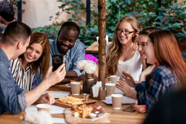 Rire et discuter sur la réunion afterworks avec des collègues dans le petit café local confortable