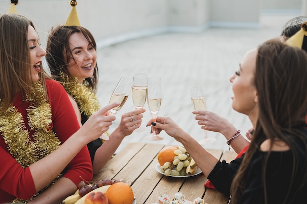 Photo gratuite rire des femmes réconfortant des coupes de champagne