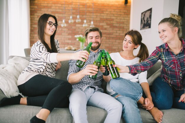 Rire les gens acclamant avec de la bière ayant des vacances