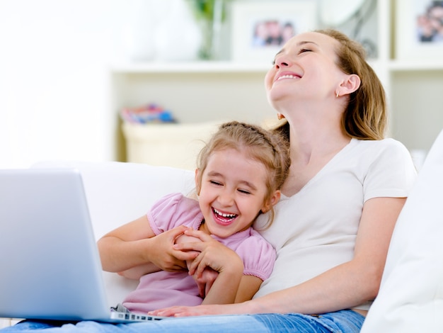 Rire mère et fille avec ordinateur portable