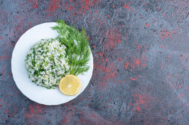 Risotto aux herbes et citron dans une assiette blanche.