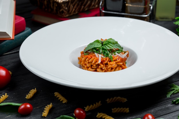 Risotto à la sauce tomate avec parmesan haché et feuilles de basilique sur le dessus