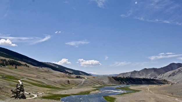 Rivière entourée de rochers sous la lumière du soleil et un ciel bleu pendant la journée