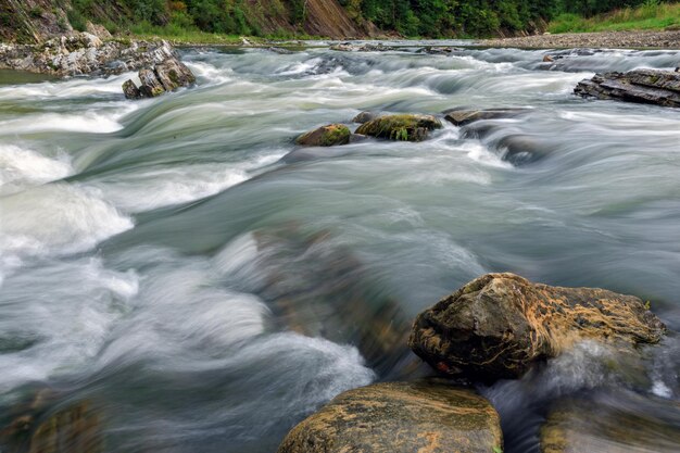 Rivière de montagne avec des rochers à longue exposition du bas de la photographie